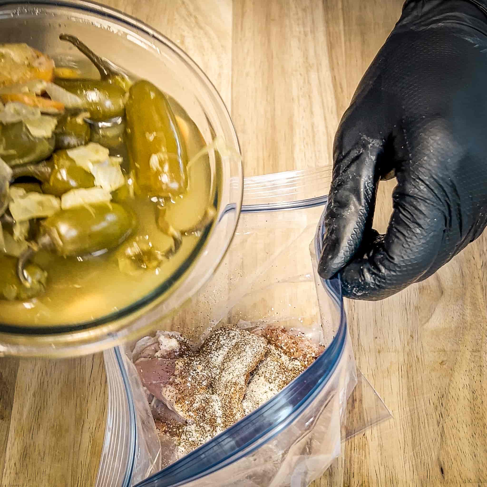 Chicken thighs marinating in with pickled jalapeño juice and green chiles