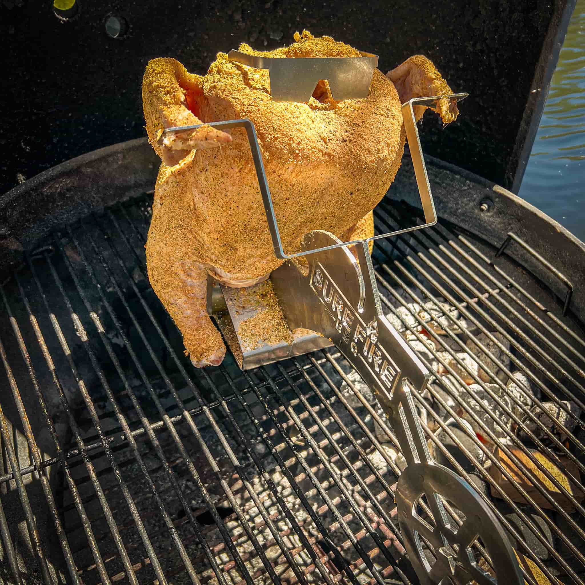 Whole chicken placed on Motorcycle Beer Can Chicken Holder and placed on grill