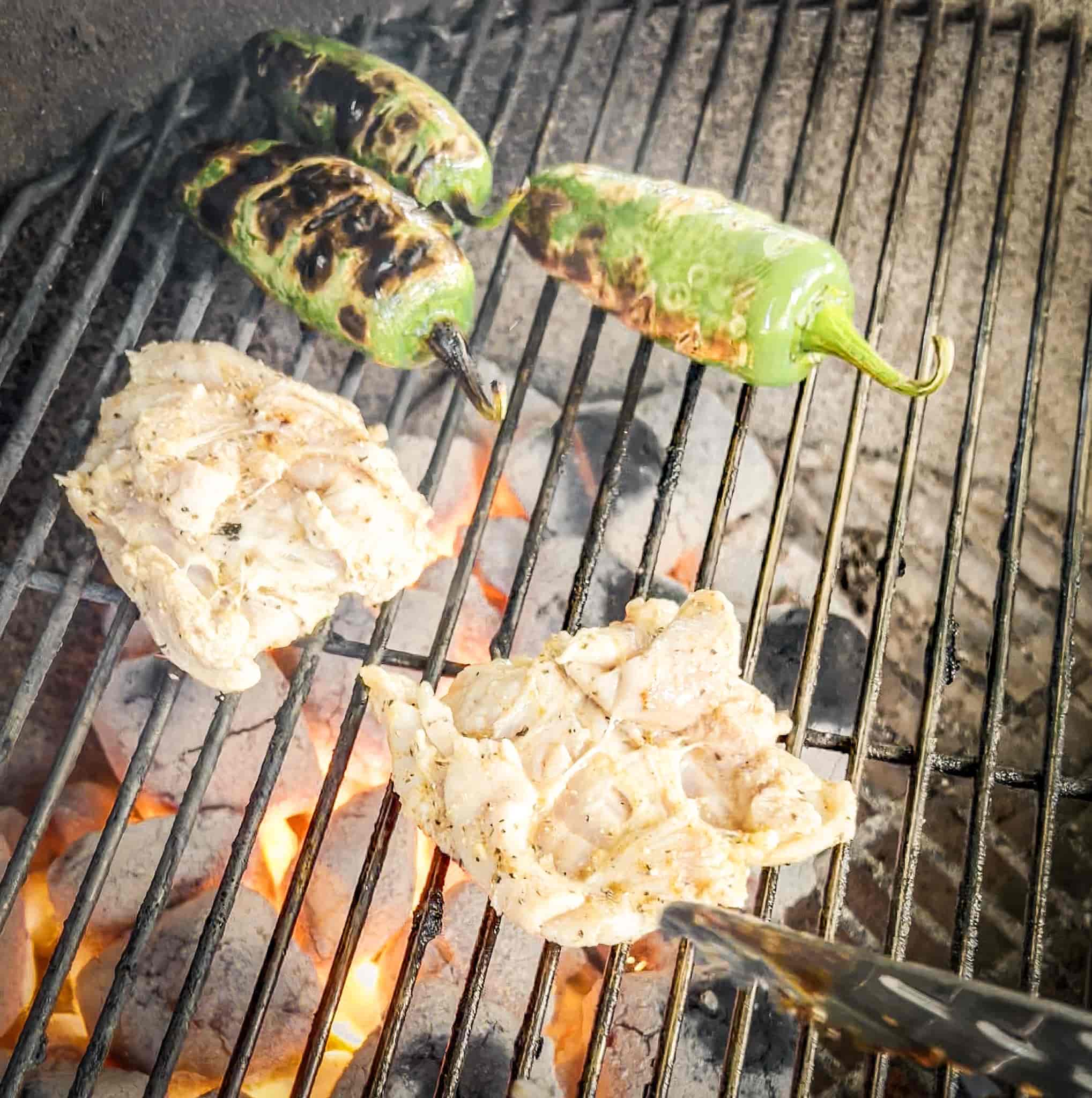 Marinated chicken thighs grilling with jalapeños on Weber Kettle