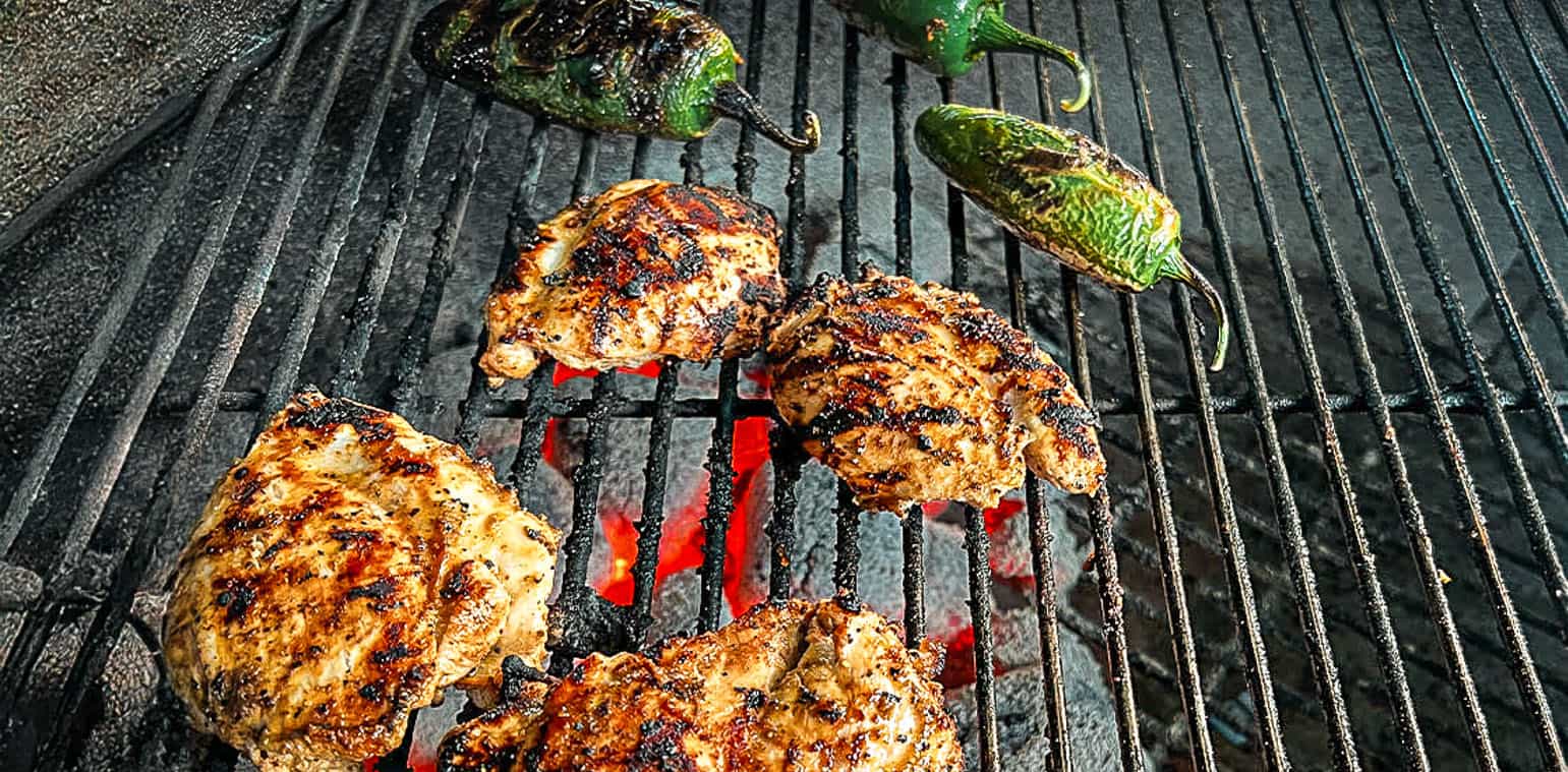 Chicken thighs seasoned with Sure Fire BBQ Fajita Seasoning on open grill